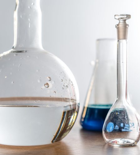 Close-up of laboratory glassware with various chemical solutions in a lab setting.
